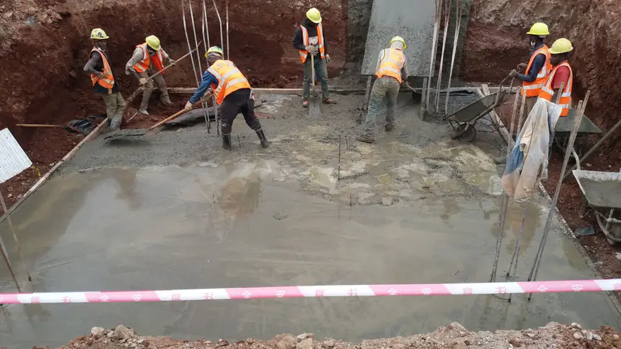 Crew placing blinding concrete in a foundation pit