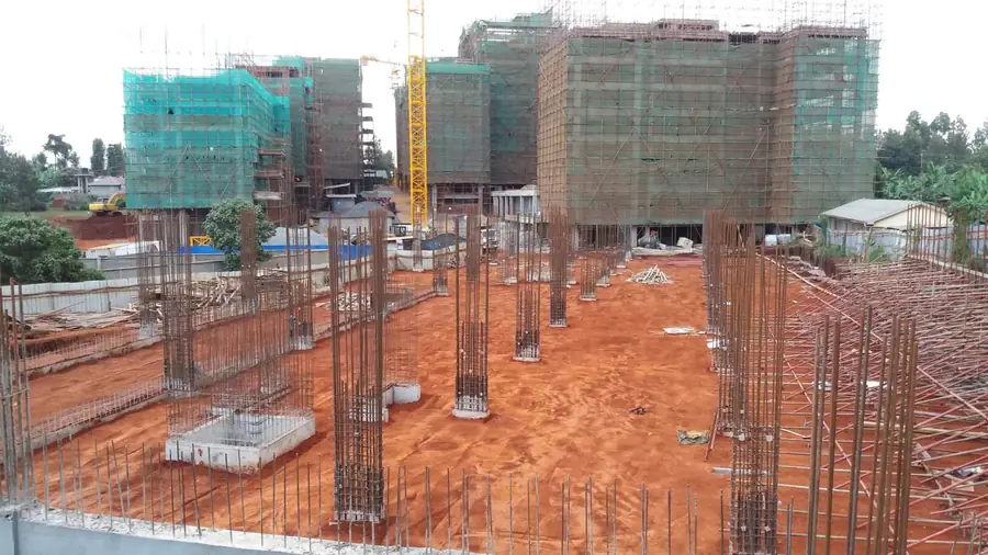 Column reinforcement rising beside completed tower blocks